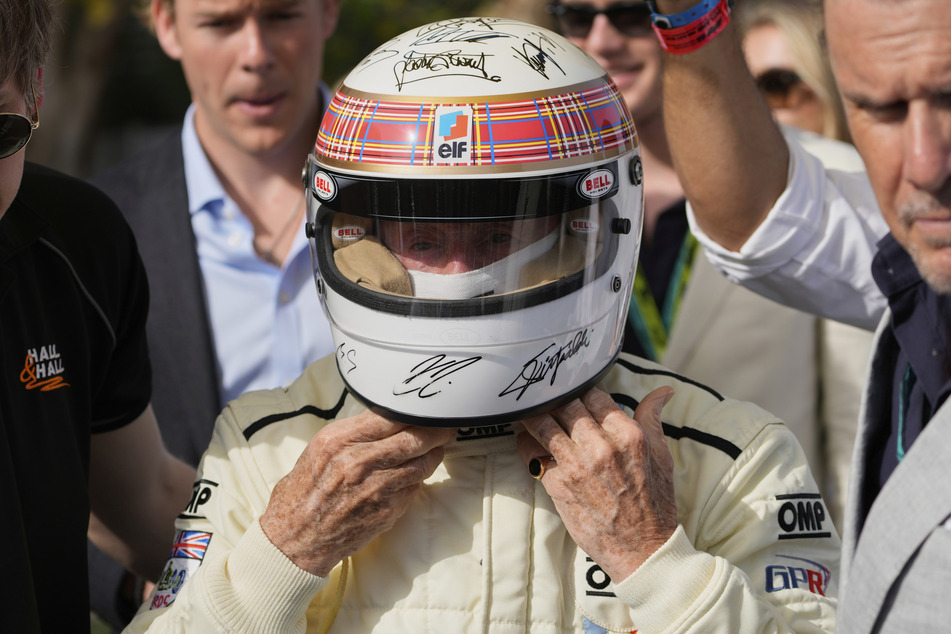Rennsport-Legende Jackie Stewart (85) trägt einen von Formel-1-Fahrern signierten Helm vor dem Rennen